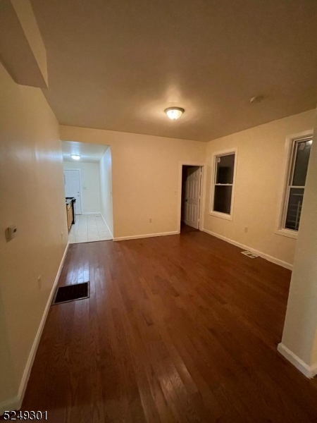89 Cutler Street, Unit 1 Newark, NJ 07104 - Photo 3 of 7 an empty room with wooden floor and windows