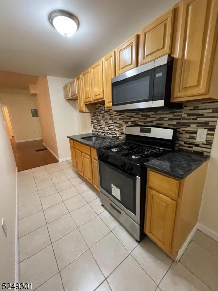 89 Cutler Street, Unit 1 Newark, NJ 07104 - Photo 4 of 7 a kitchen with stainless steel appliances a stove a microwave a sink and cabinets