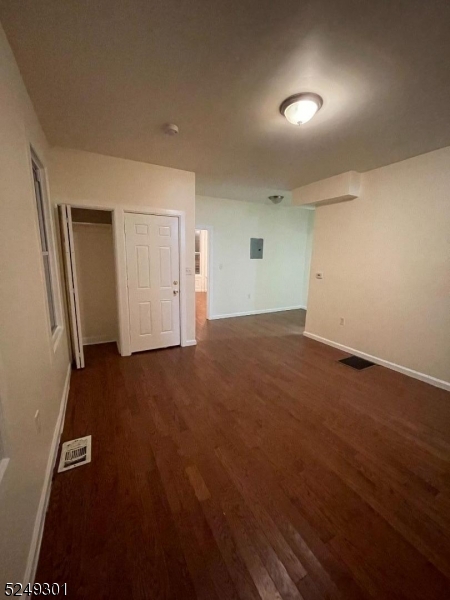 89 Cutler Street, Unit 1 Newark, NJ 07104 - Photo 5 of 7 an empty room with wooden floor and windows