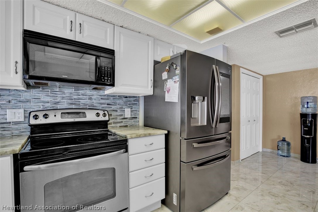 4204 Medina Way Sebring, FL 33875 - Photo 12 of 25 a kitchen with stainless steel appliances and cabinets