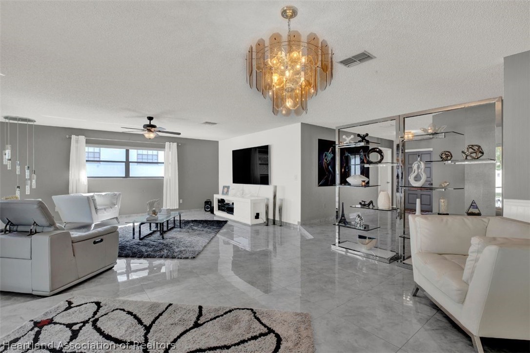 4204 Medina Way Sebring, FL 33875 - Photo 6 of 25 a living room with furniture and a chandelier