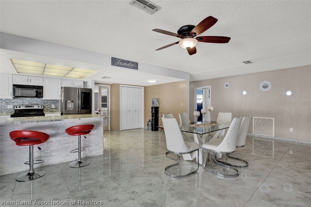 4204 Medina Way Sebring, FL 33875 - Photo 8 of 25 a dining room with stainless steel appliances kitchen island granite countertop furniture and a view of kitchen