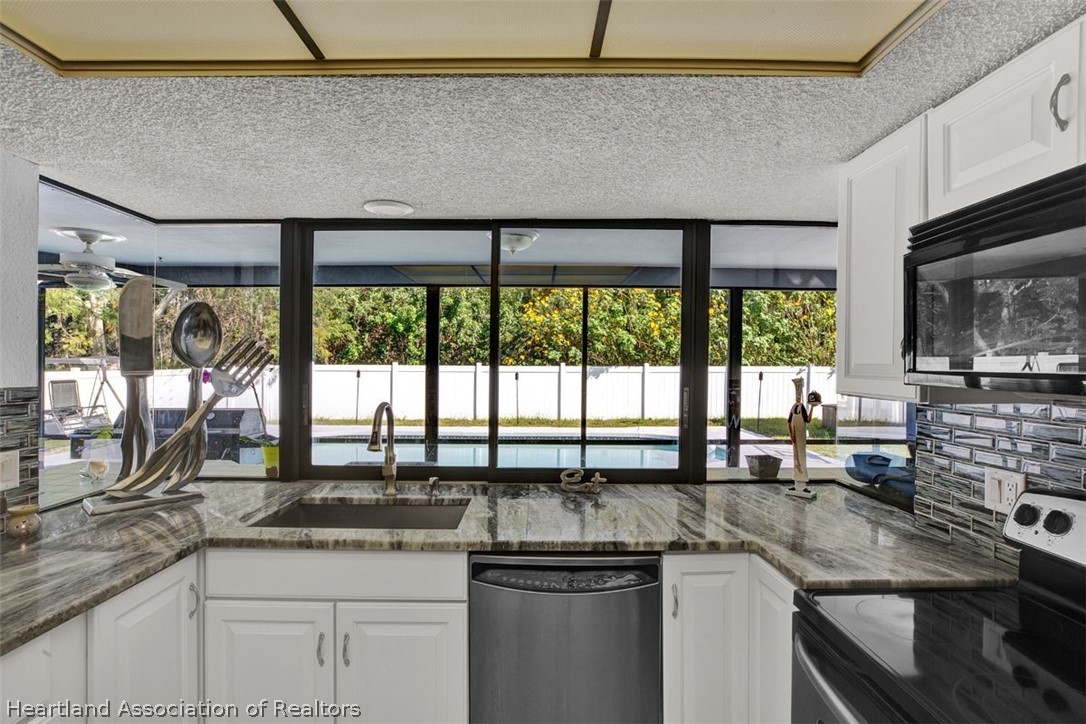 4204 Medina Way Sebring, FL 33875 - Photo 10 of 25 a kitchen with a sink a counter top and stainless steel appliances