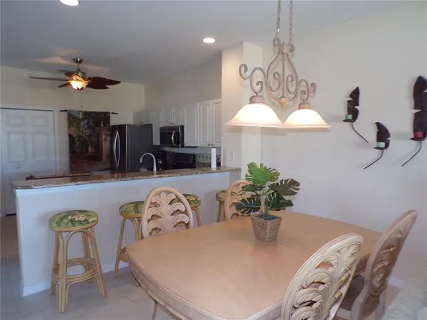 a dining room with furniture a chandelier and kitchen view
