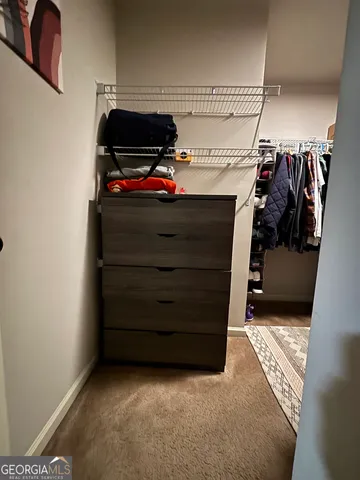 a view of walk in closet with clothes and shoes