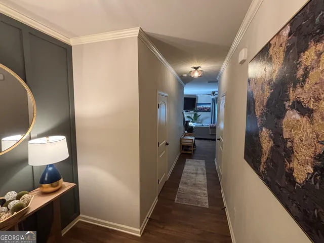a view of a hallway with furniture and wooden floor