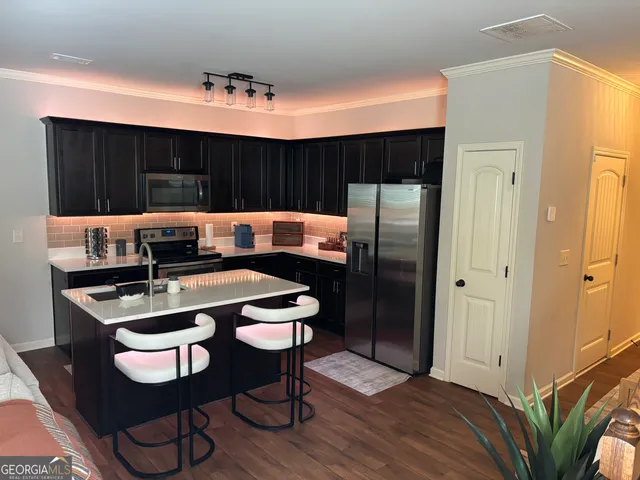 a kitchen with a table chairs refrigerator and cabinets