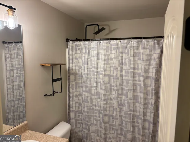 a bathroom with a toilet and a shower curtain