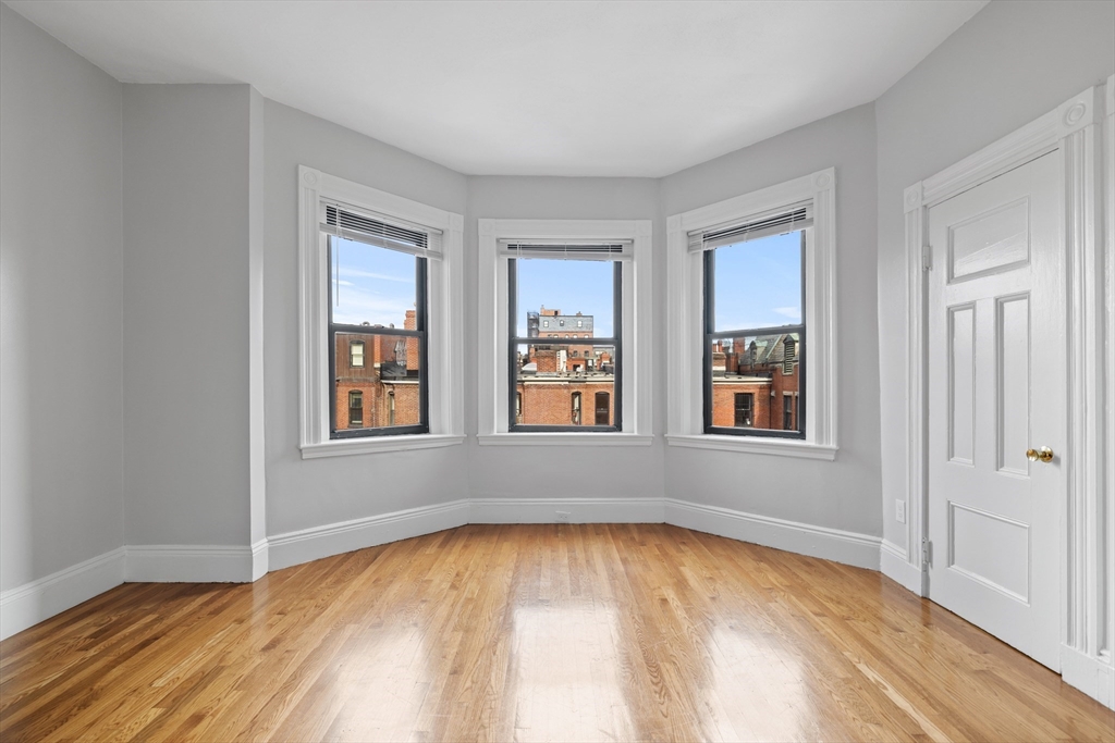 907 Boylston Street, Unit 32 Boston, MA 02115 - Photo 3 of 9 a view of empty room with wooden floor and fan