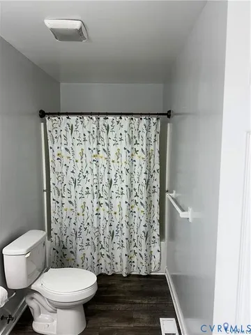 a bathroom with a toilet and a shower curtain