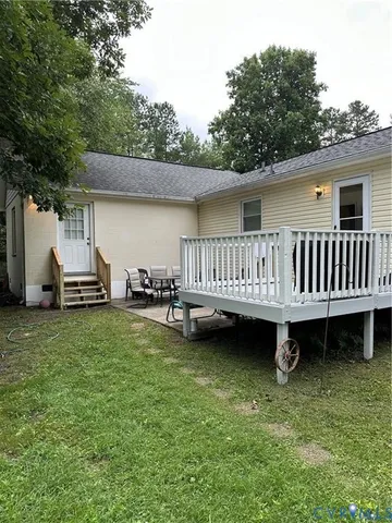 a view of a house with backyard and deck