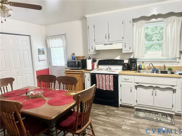 a kitchen that has a dining table chair and a stove