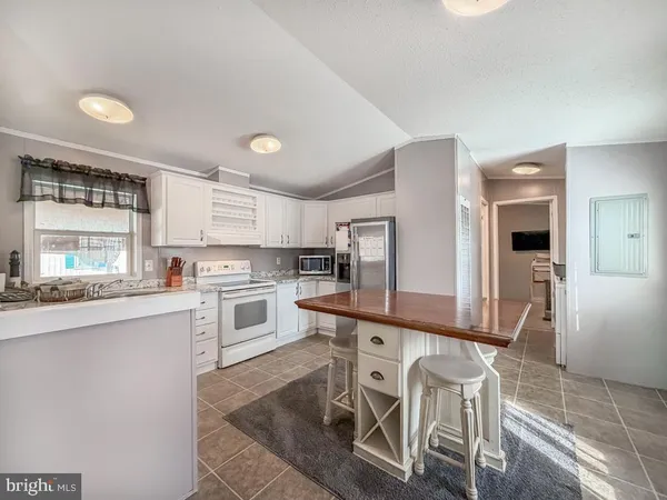 a kitchen with stainless steel appliances granite countertop a stove top oven a sink dishwasher and white cabinets