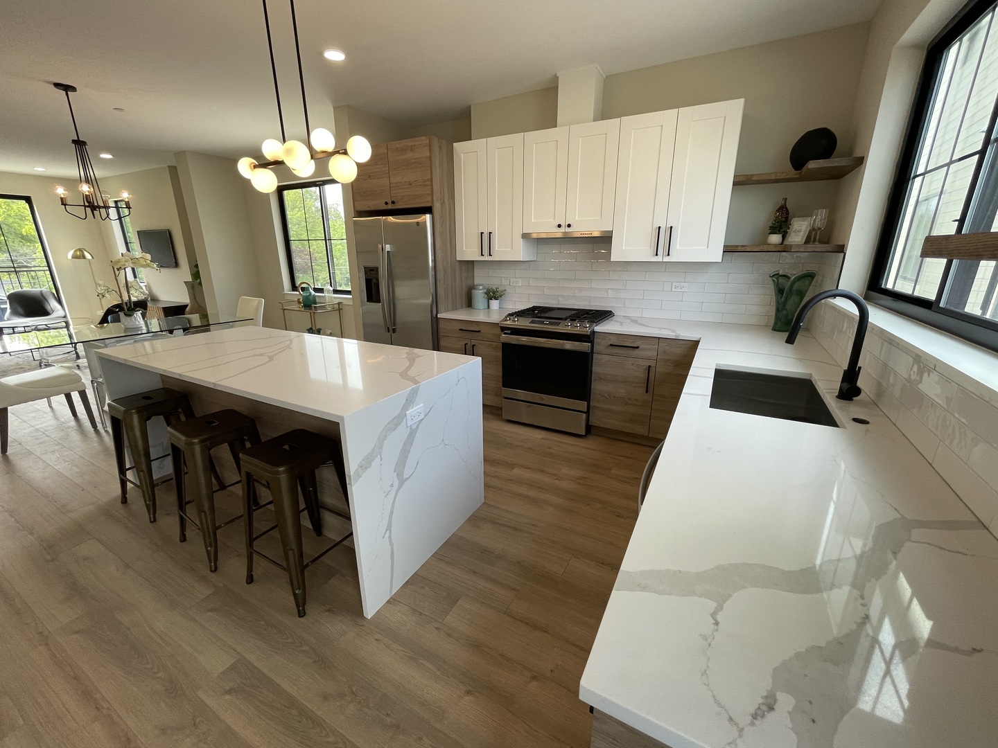 425 Bloom Street, Unit U Highland Park, IL 60035 - Photo 6 of 8 a kitchen with stainless steel appliances kitchen island granite countertop a stove a sink a refrigerator and a dining table with wooden floor