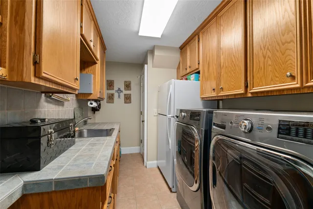 a kitchen with stainless steel appliances granite countertop a refrigerator a stove and a sink with wooden floor
