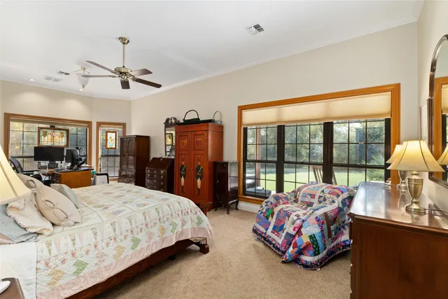 a bedroom with bed and large windows