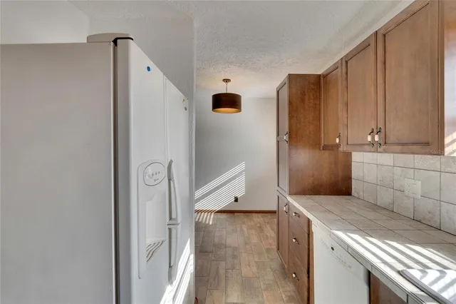 a kitchen with granite countertop a refrigerator and a stove top oven