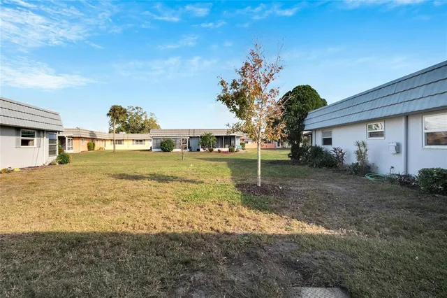 a view of a house with backyard and sitting area