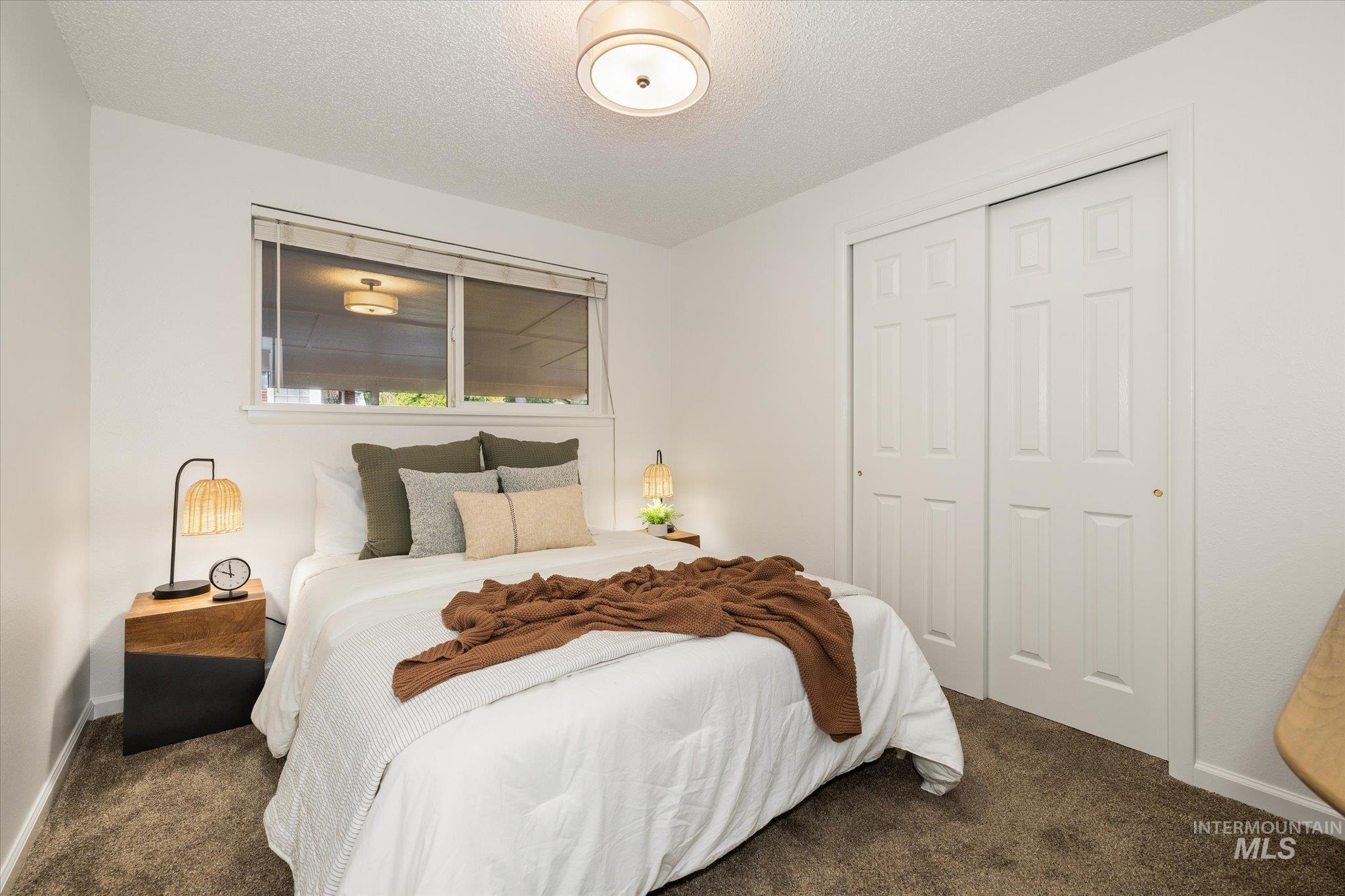 2302 Pendleton Street Boise, ID 83705 - Photo 25 of 35 Bedroom featuring textured carpeting, a window with blinds, and white bi-fold closet doors