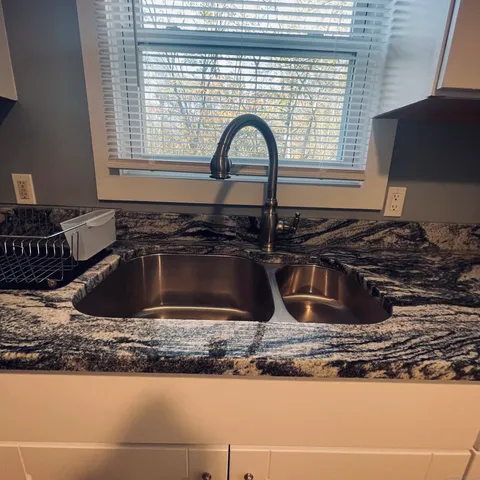 a kitchen with sink a window and a stove