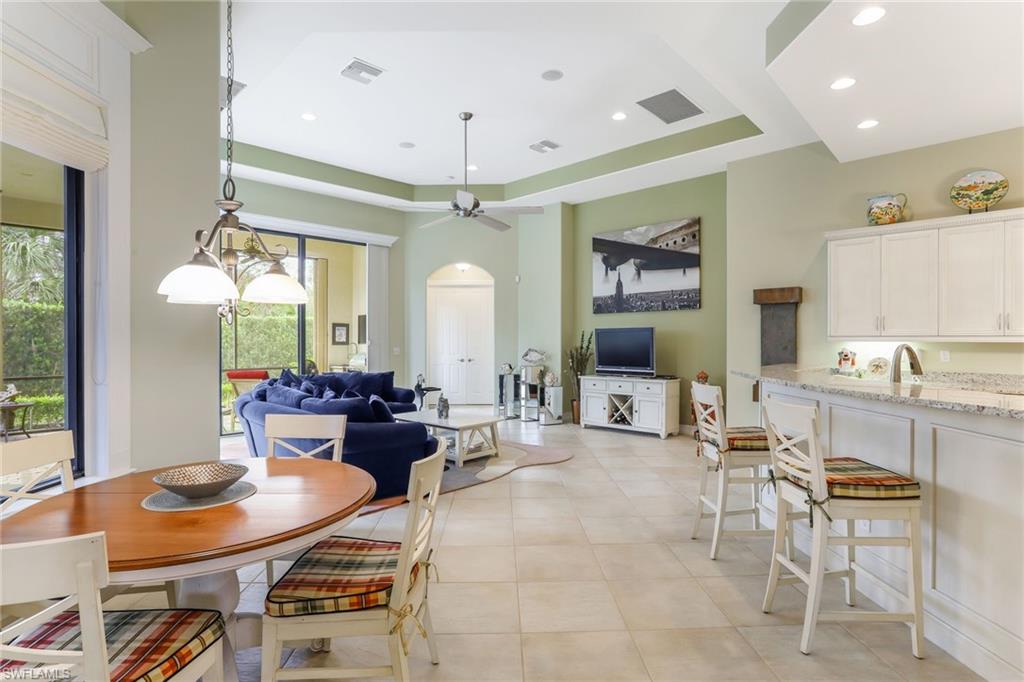 7433 Byrons Way Naples, FL 34113 - Photo 11 of 34 a living room with furniture a chandelier and a flat screen tv