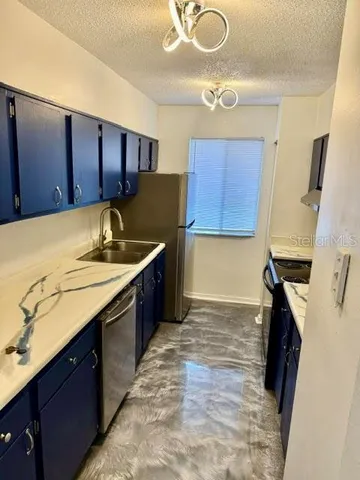 a kitchen with a sink a stove cabinets and a wooden floor