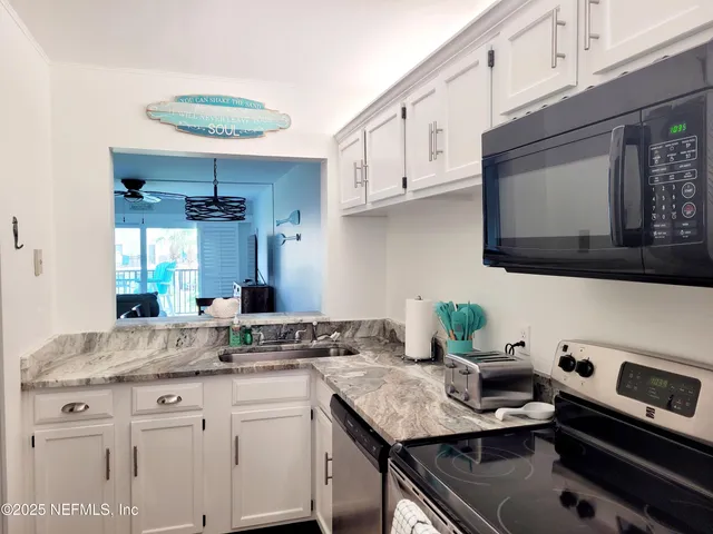 a kitchen with stainless steel appliances granite countertop a sink stove and cabinets