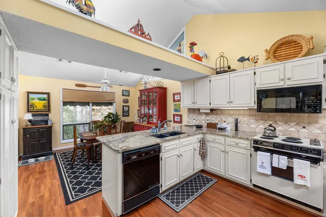 a kitchen with stainless steel appliances granite countertop a sink stove and cabinets
