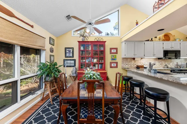 a dining room with stainless steel appliances kitchen island granite countertop a table and chairs