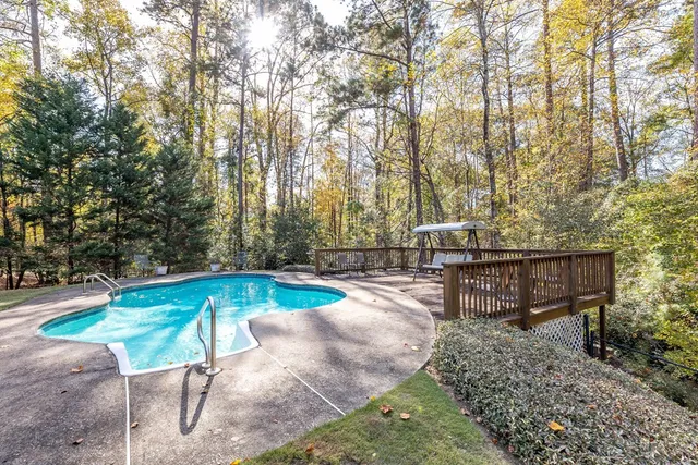 a view of a swimming pool with a patio and fire pit