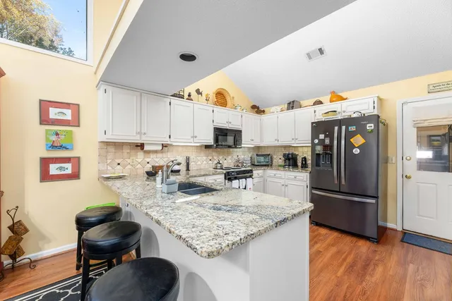a kitchen with granite countertop lots of counter top space appliances and cabinets