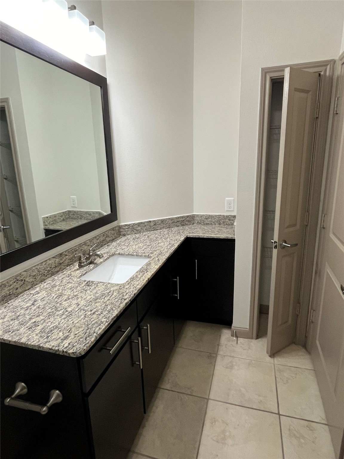 2700 Brazos Street, Unit 4515 Houston, TX 77006 - Photo 8 of 20 a bathroom with a granite countertop sink and a mirror