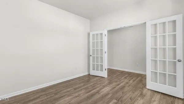 an empty room with wooden floor and empty shelves