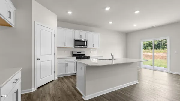 a kitchen with kitchen island granite countertop appliances cabinets and a sink