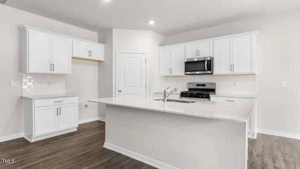 a kitchen with stainless steel appliances a stove a sink and white cabinets
