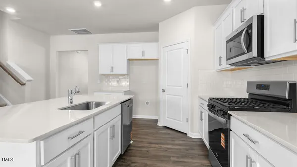 a kitchen with stainless steel appliances granite countertop a sink stove cabinets and wooden floor