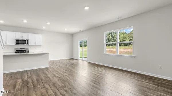an open kitchen with granite countertop a stove top oven a sink and dishwasher with wooden floor