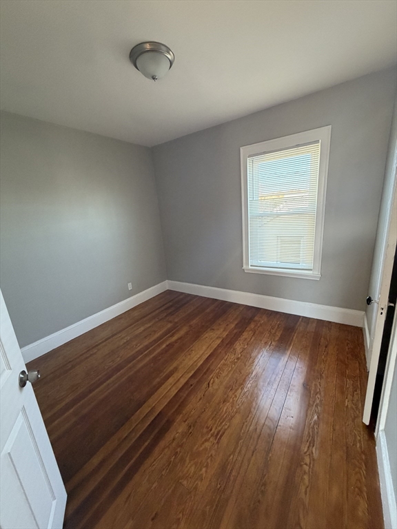 49 Federal Street, Unit 3 Beverly, MA 01915 - Photo 4 of 10 an empty room with wooden floor and windows