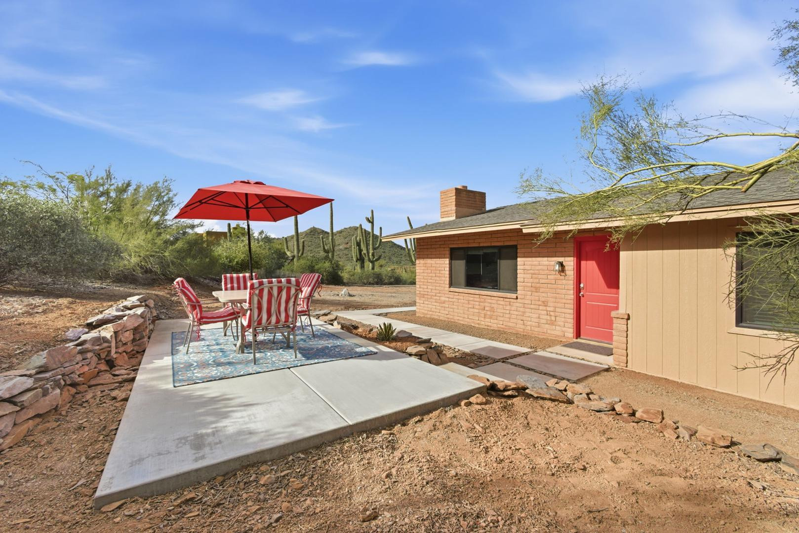 36975 North Sunset Trail Cave Creek, AZ 85331 - Photo 1 of 27 a patio with a table and chairs under an umbrella