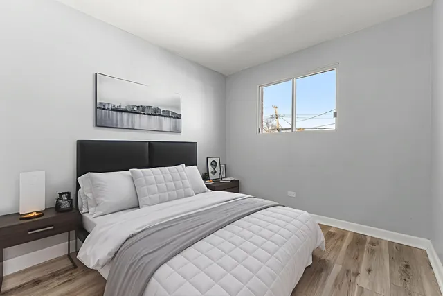 a bedroom with a bed and a wooden floor