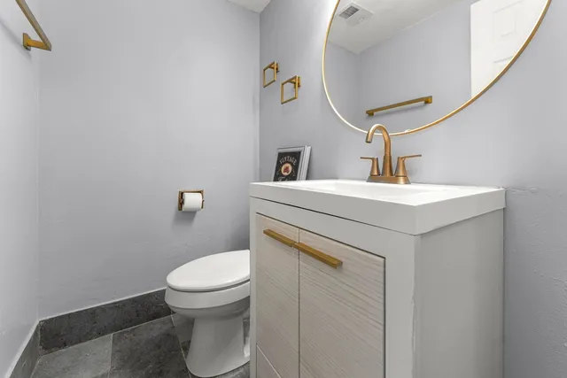 a bathroom with a sink a toilet and mirror