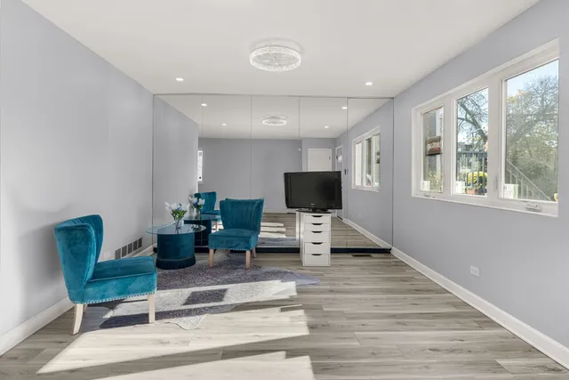 a living room with furniture a flat screen tv and a large window