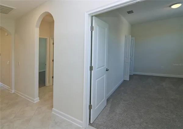 an empty room with windows and mirror