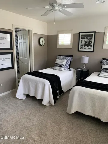a bedroom with two beds and painting on the wall