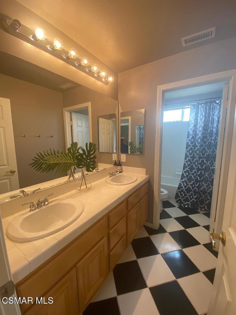 3082 Eaglewood Avenue Thousand Oaks, CA 91362 - Photo 23 of 29 a bathroom with a sink a toilet a mirror and shower
