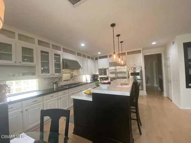 a kitchen with stainless steel appliances kitchen island granite countertop a sink and cabinets