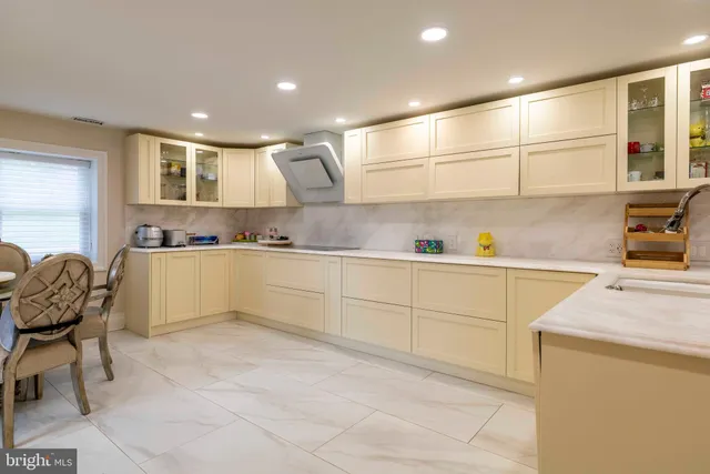 a large white kitchen with a large window and stainless steel appliances