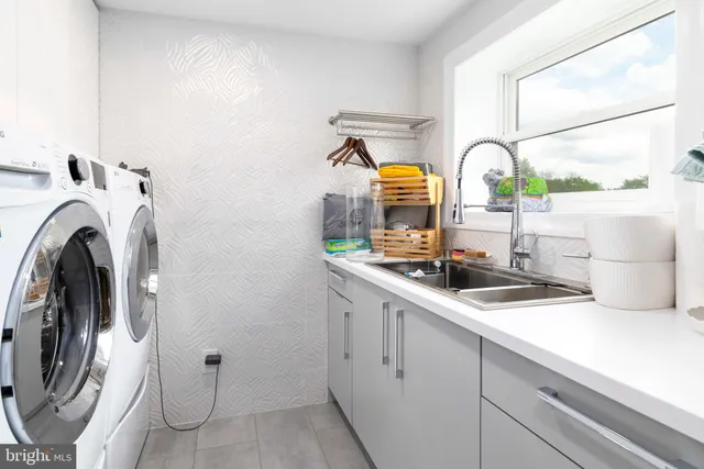 a kitchen with a sink dishwasher stove and white cabinets with wooden floor