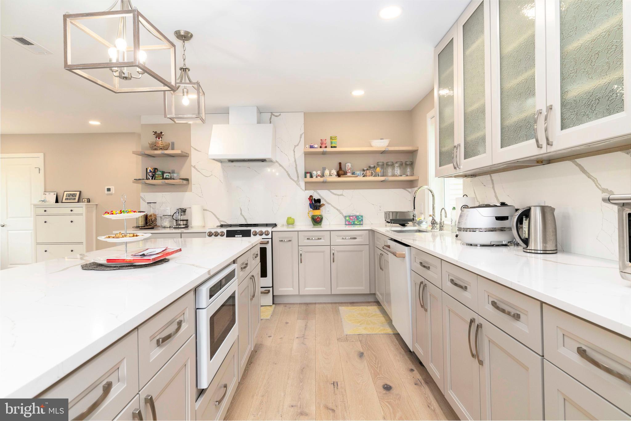 1851 Meetinghouse Road Warminster, PA 18974 - Photo 36 of 66 a kitchen with a sink dishwasher stove and white cabinets with wooden floor