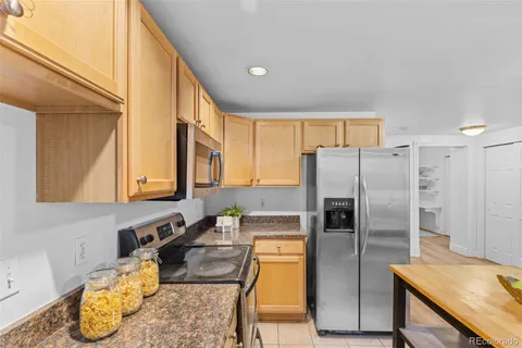 a kitchen with stainless steel appliances granite countertop a refrigerator a stove and a sink
